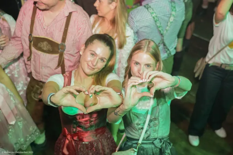 Zwei Besucherinnen im Dirndl formen ein Herz mit den Händen